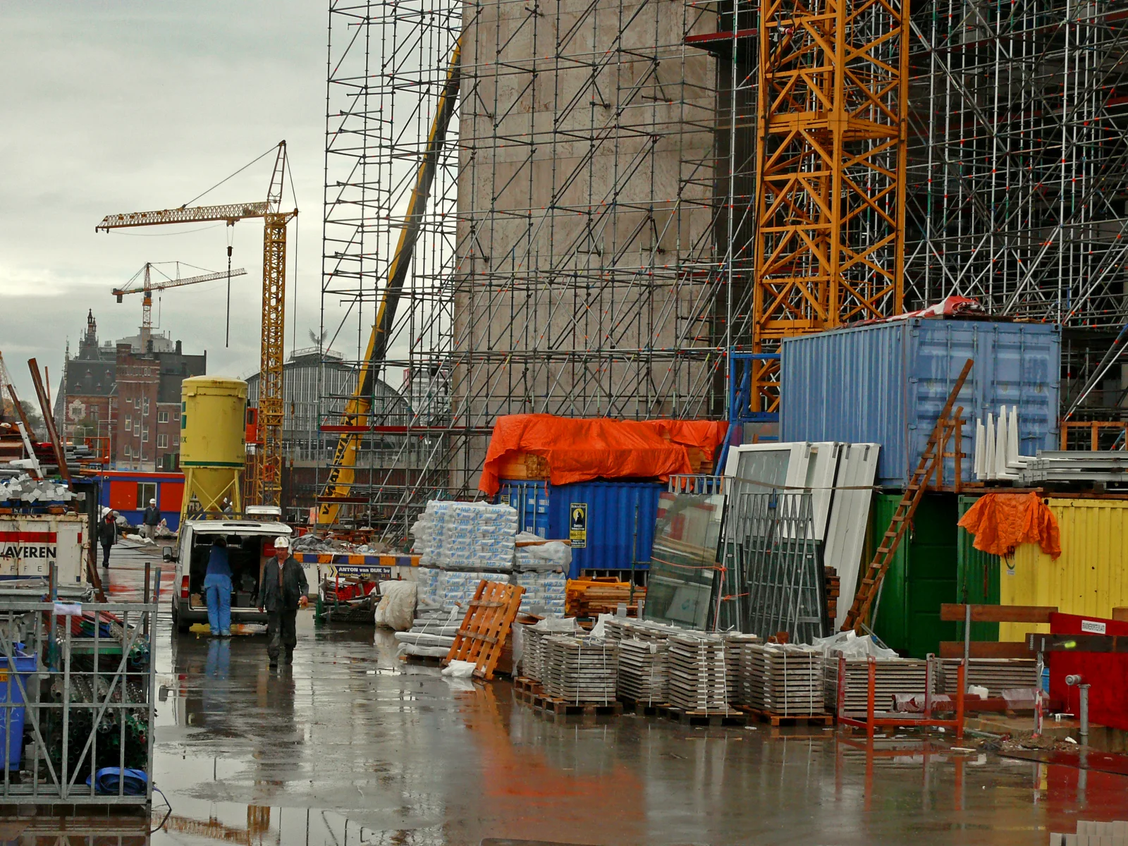 Bouwplaats op het Oosterdokseiland in Amsterdam met steigers, kranen en bouwvakkers