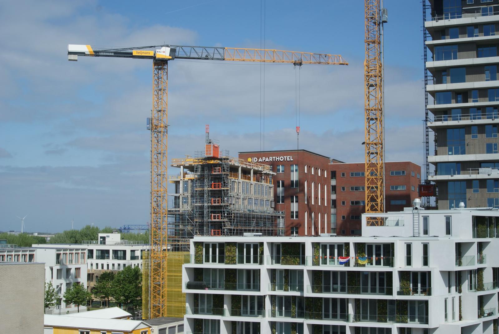 Bouwplaats met kranen en woningbouw in uitvoering