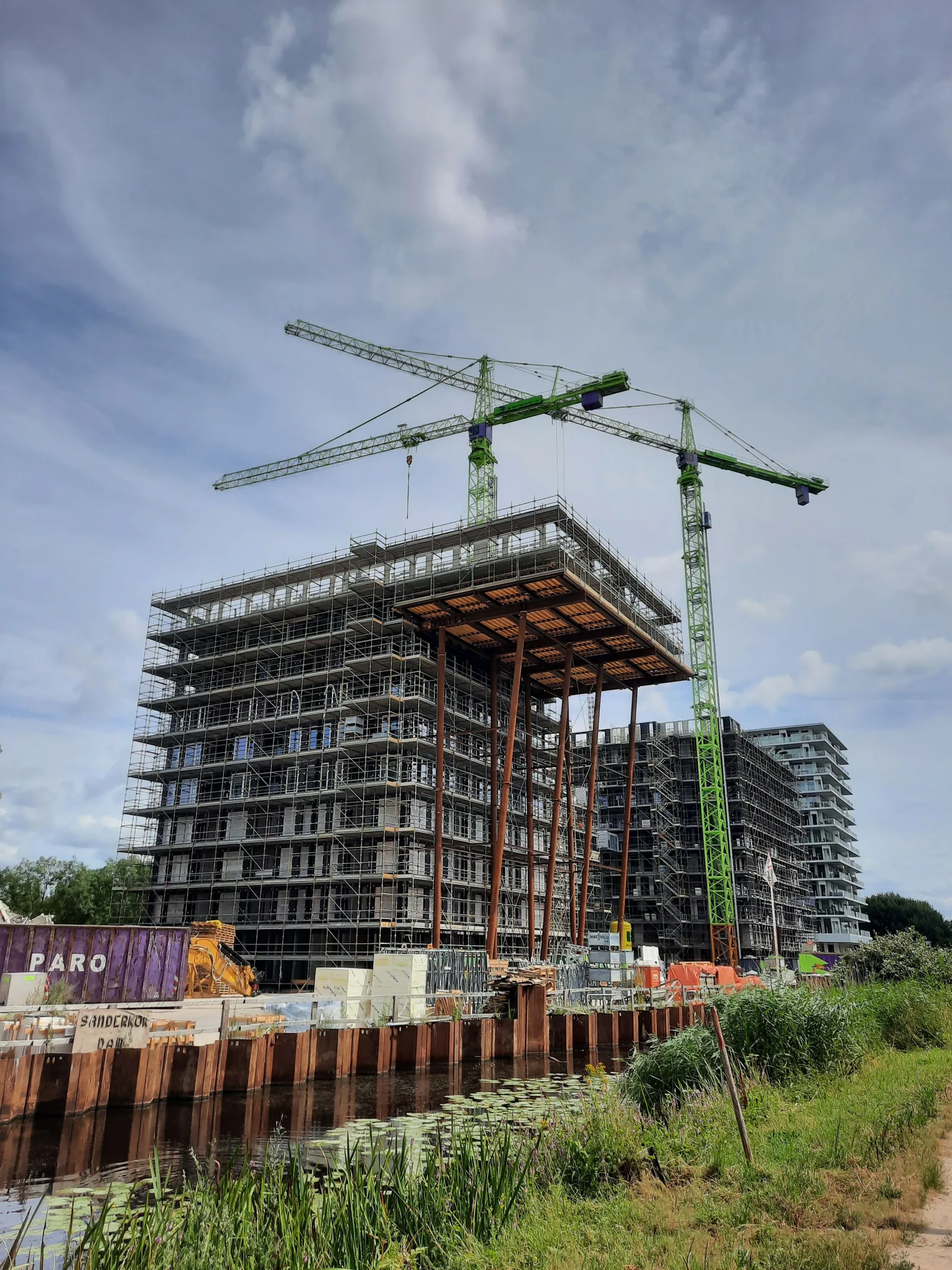 Bouwplaats met hoogbouw, steigers en bouwkranen
